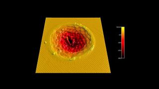 Crater in a sapphire substrate hit with a femtosecond laser pulse, followed by annealing to develop the step structure. The top surface is covered with single atomic steps (3Å).